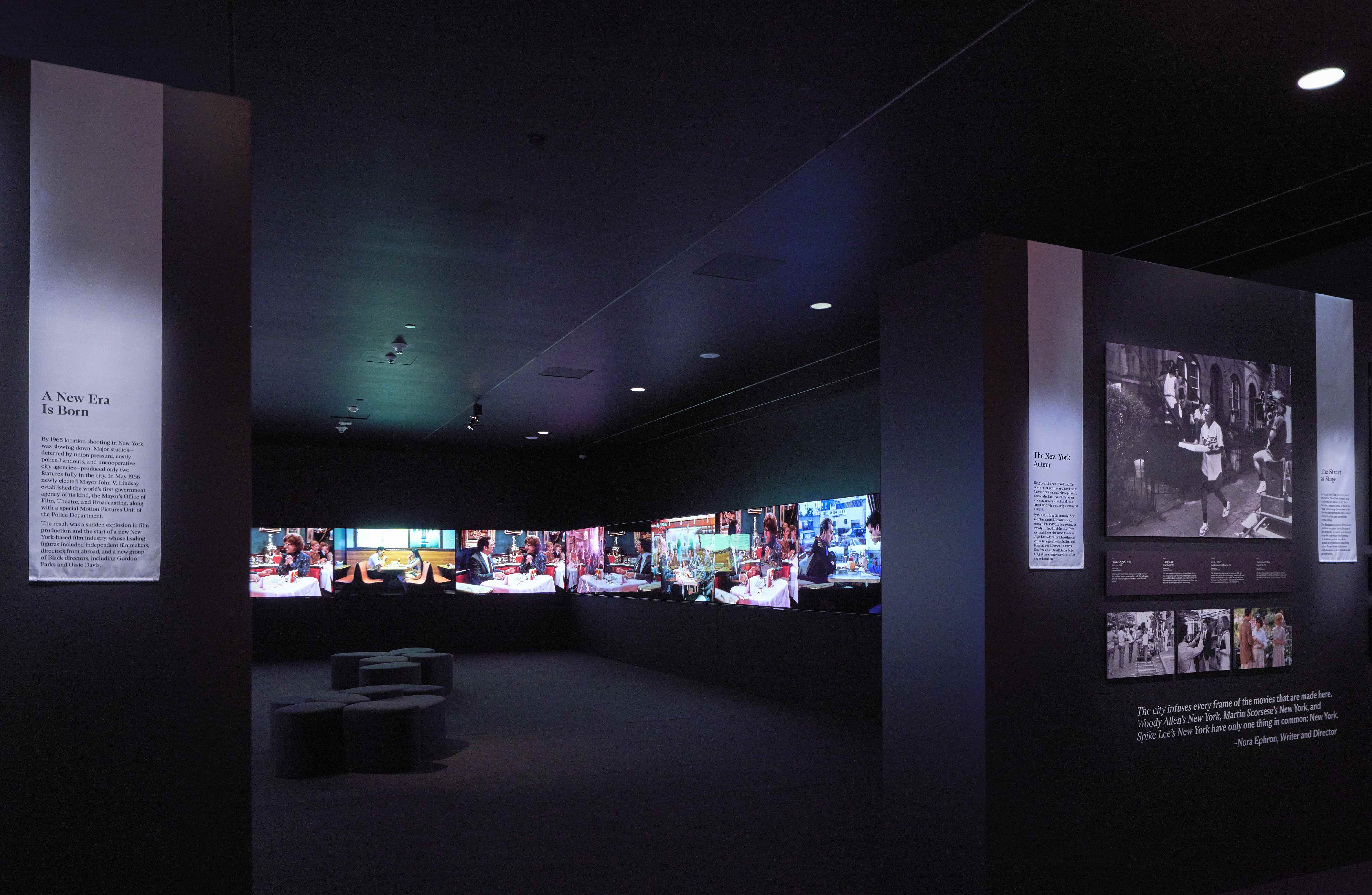 A dark room with several large screens. 